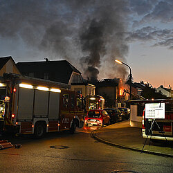 Brennendes Wohnhaus mit Rauchwolken im Morgengrauen