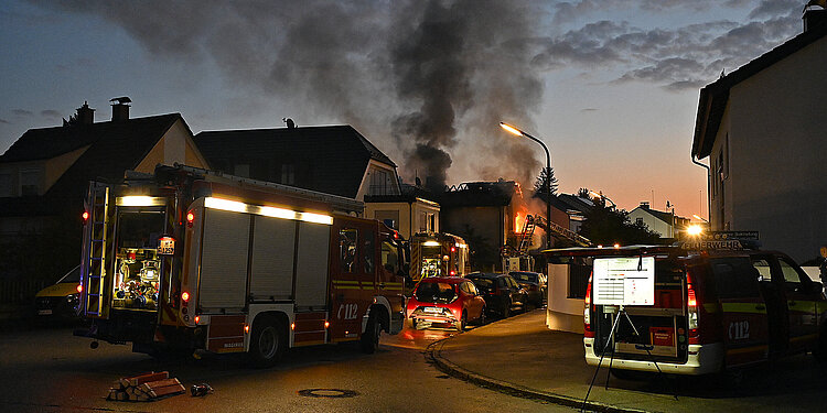 Brennendes Wohnhaus mit Rauchwolken im Morgengrauen
